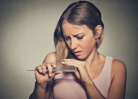 woman looking at falling hair