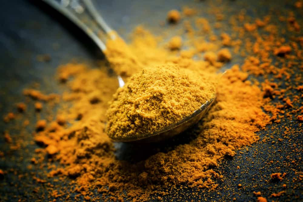 ground turmeric on spoon